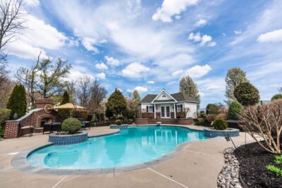 Resurfaced concrete pool deck around a backyard pool